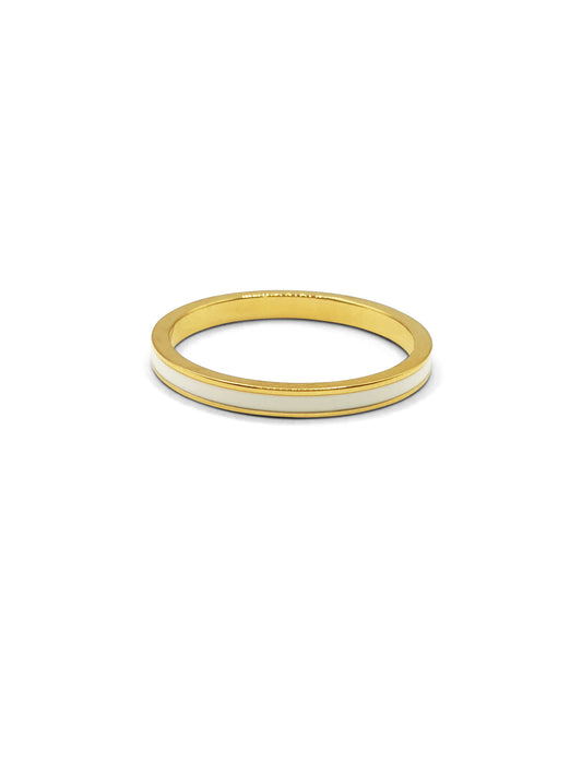 A gold band ring with white enamel banding around the middle sits against a white background