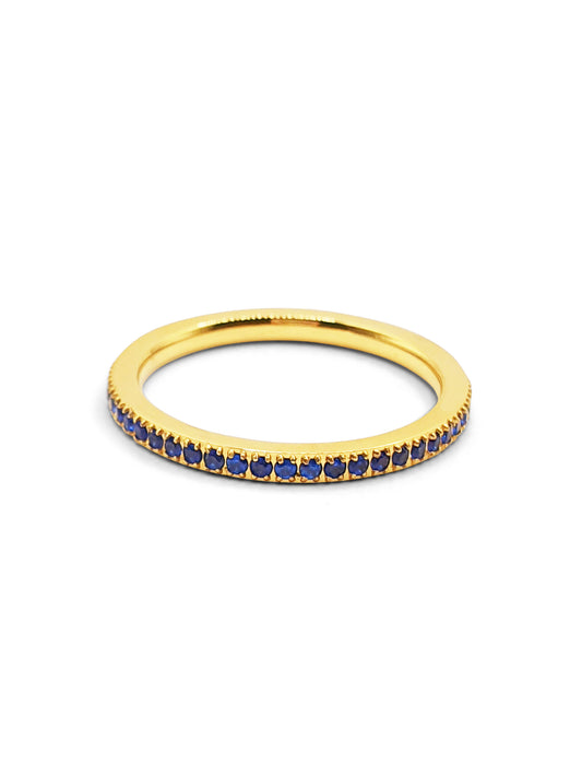 Gold eternity ring set with dark blue stones