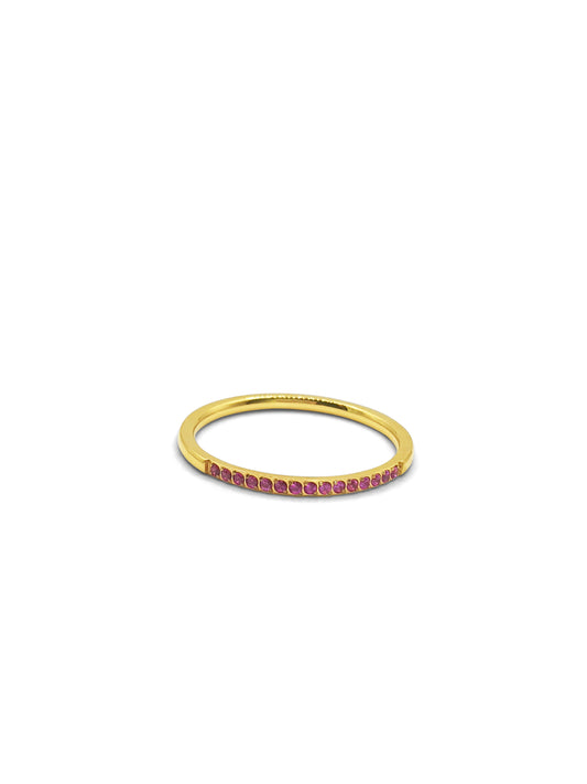 A gold stackable band ring set at the top with small pink gems